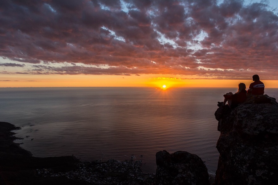 Two people watching the sunset over the Atlantic from Table Mountain